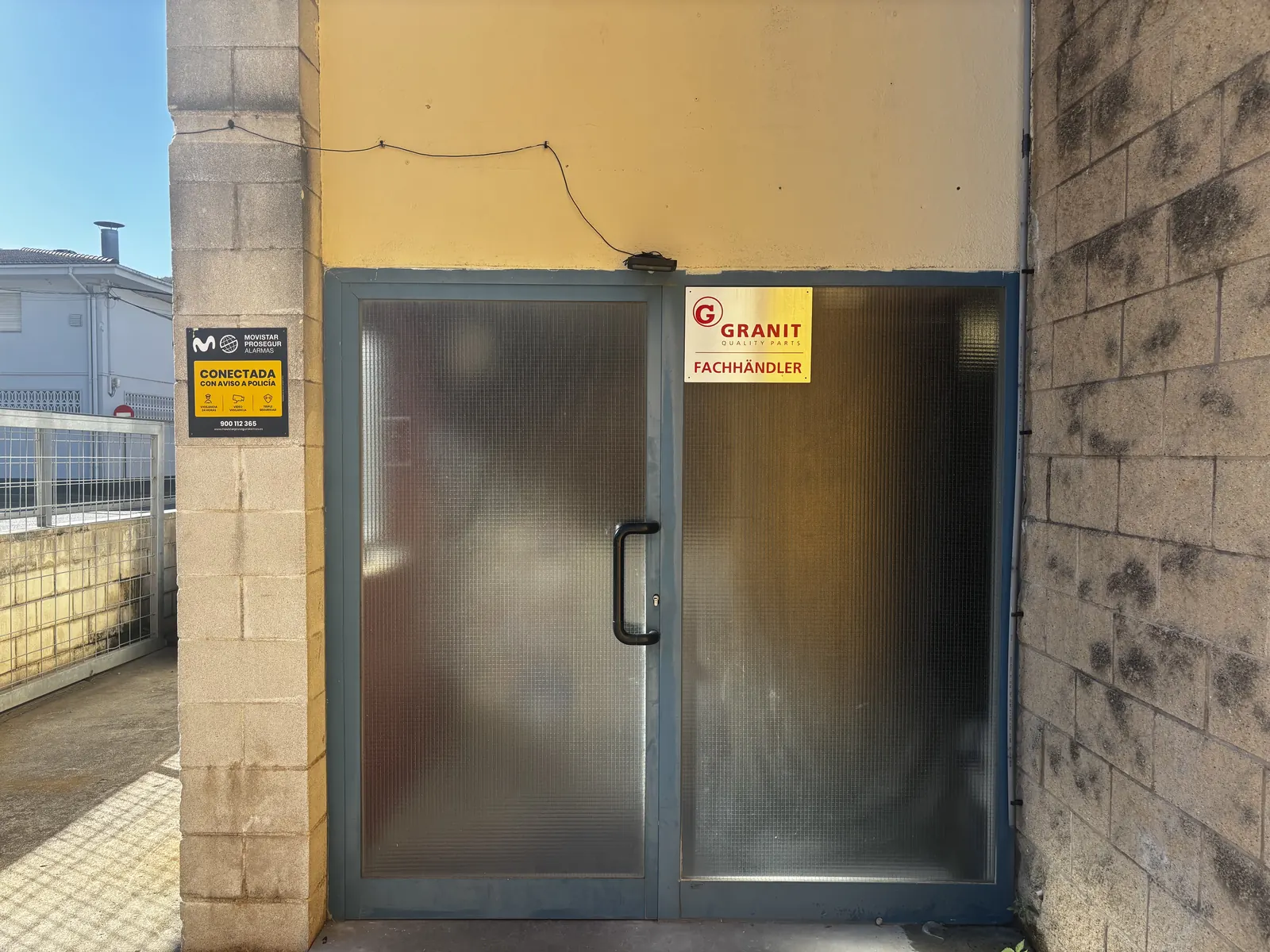 La porta d'entrada de la botiga, amb la placa de distribuïdor Granit