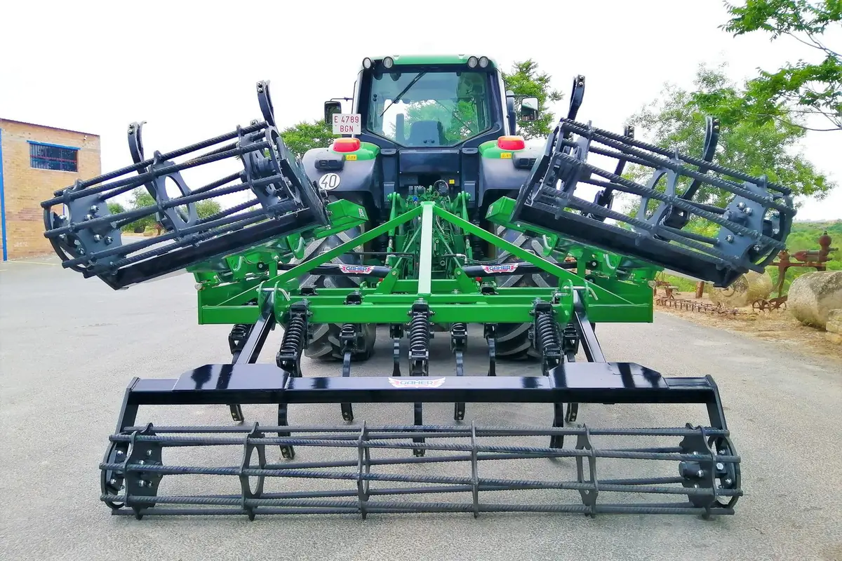 Semixissel plegable Gaher plegat en posició de transport darrere d'un tractor, vist des del darrere, sobre asfalt