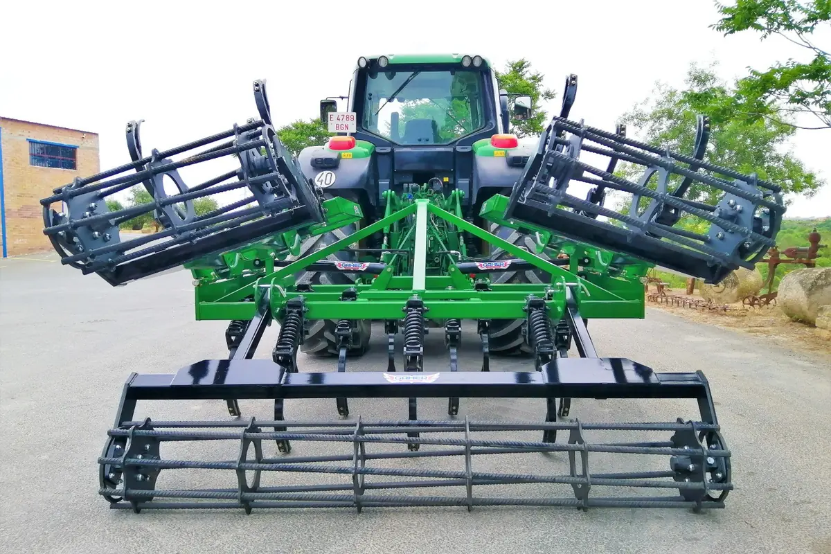 Xissel plegable Gaher Sèrie Rapid plegat darrere d'un tractor verd, vist des del darrere, sobre asfalt