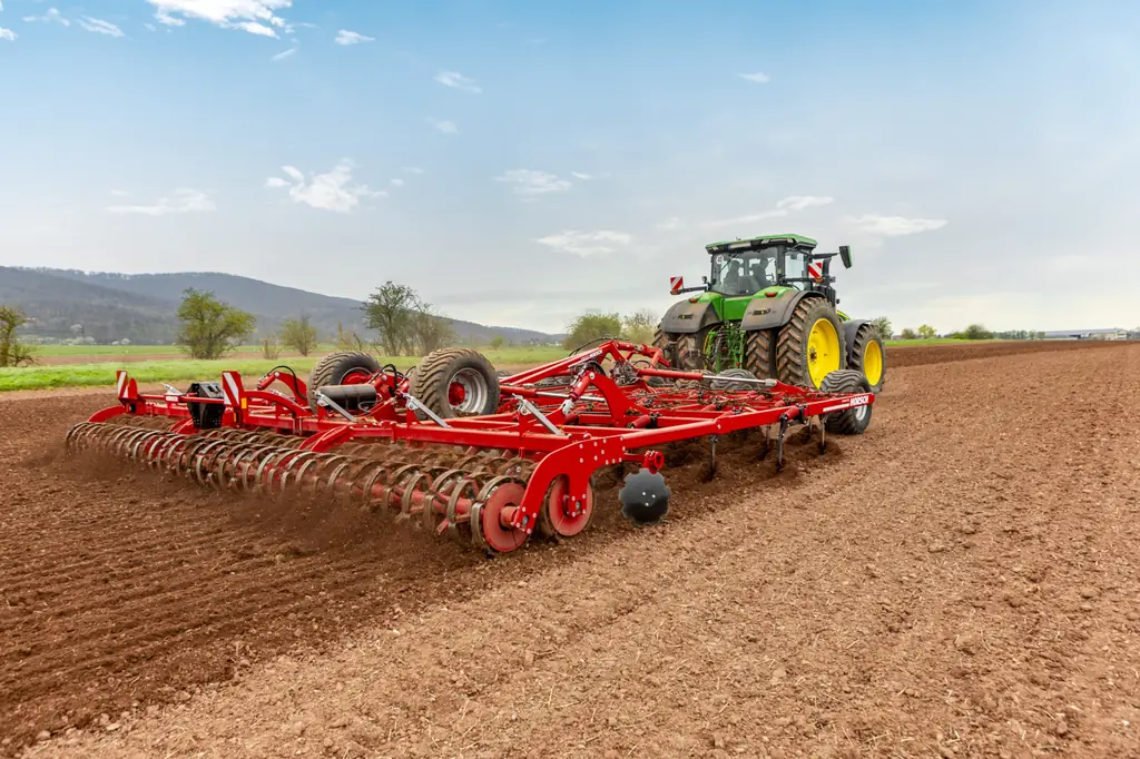 Cultivador Horsch Cruiser 7-12 XL de tres quarts amb el tractor, sobre terra treballada