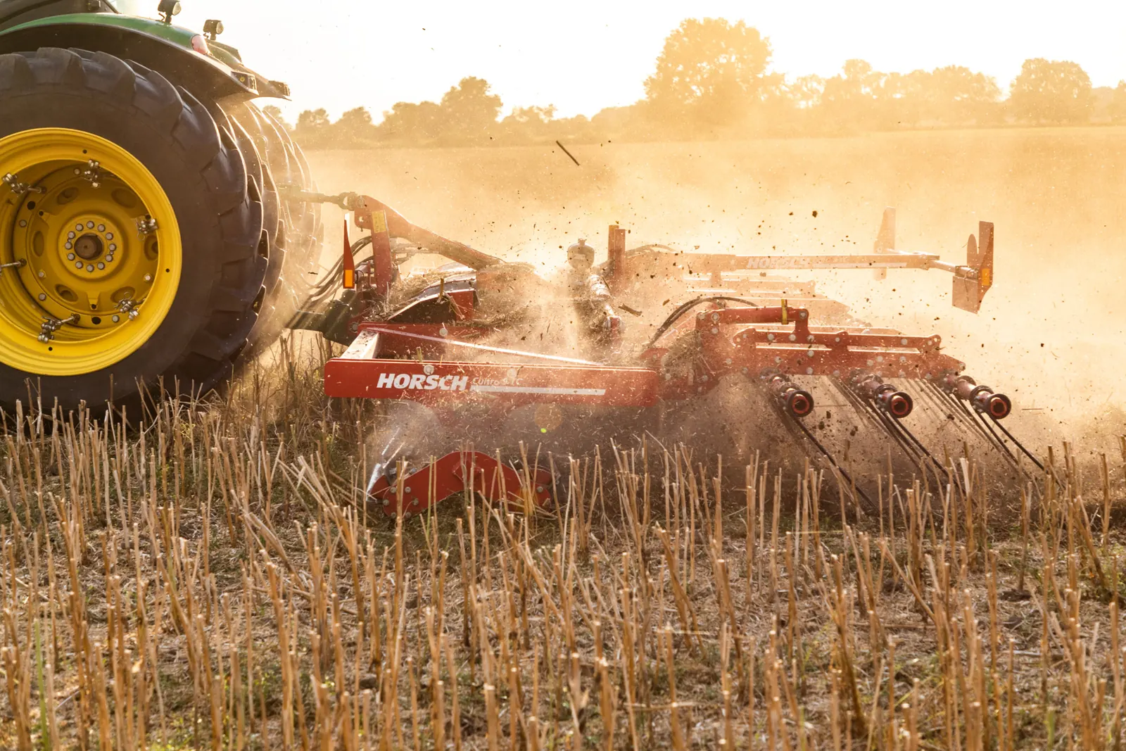 Corró de ganivetes Horsch Cultro trencant el rostoll amb la roda del tractor en primer terme i la palla saltant