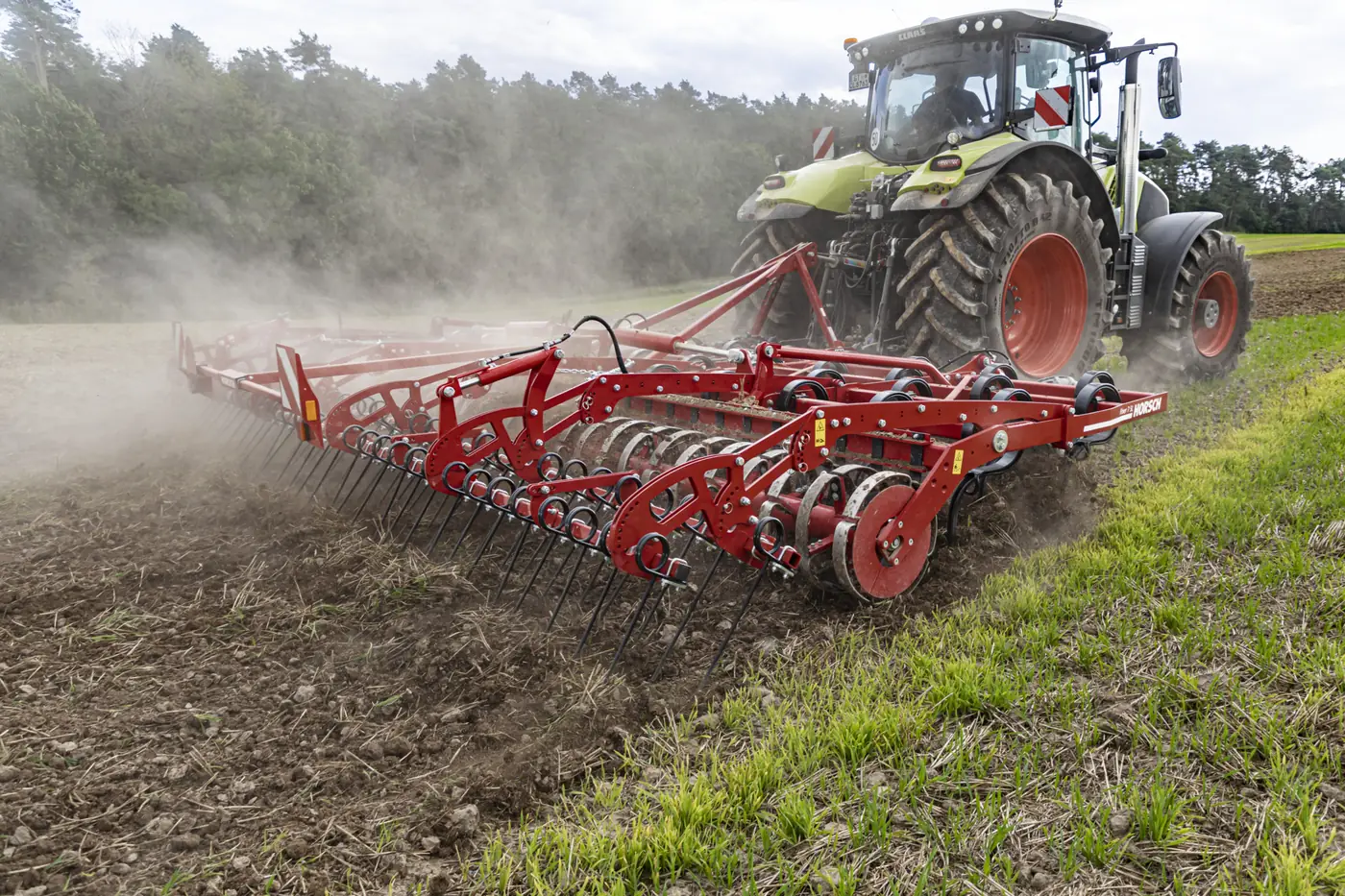 Cultivador Horsch Finer aixecant un núvol de pols darrere d'un tractor, al caire d'un camp de rostoll