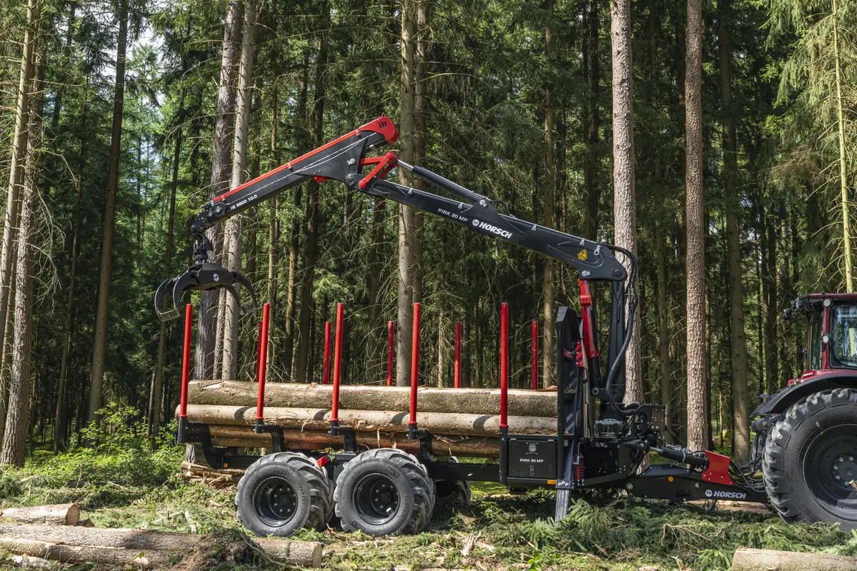 Remolc forestal Horsch Pirk 20 MP dins del bosc amb troncs a la caixa i la grua alçada, amb la pinça oberta damunt la càrrega