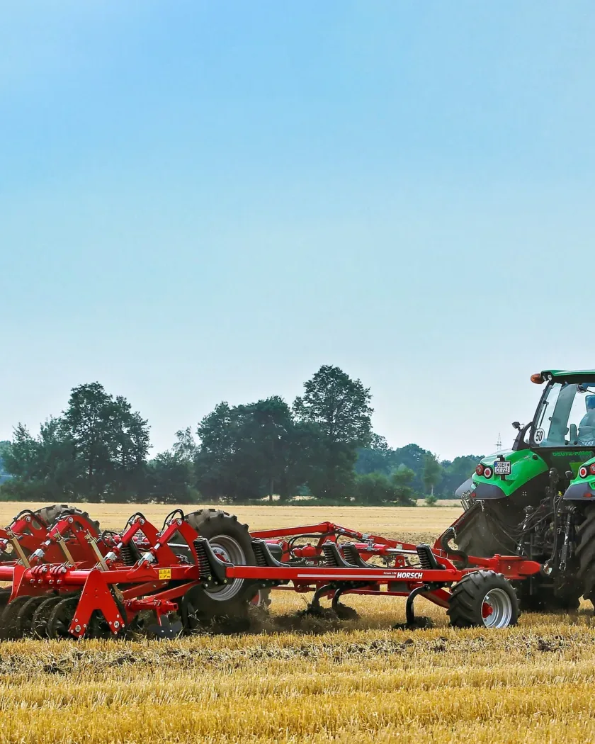 Cultivador Horsch Terrano FM desplegat treballant un rostoll de cereal, estirat per un tractor, amb el cel obert al damunt
