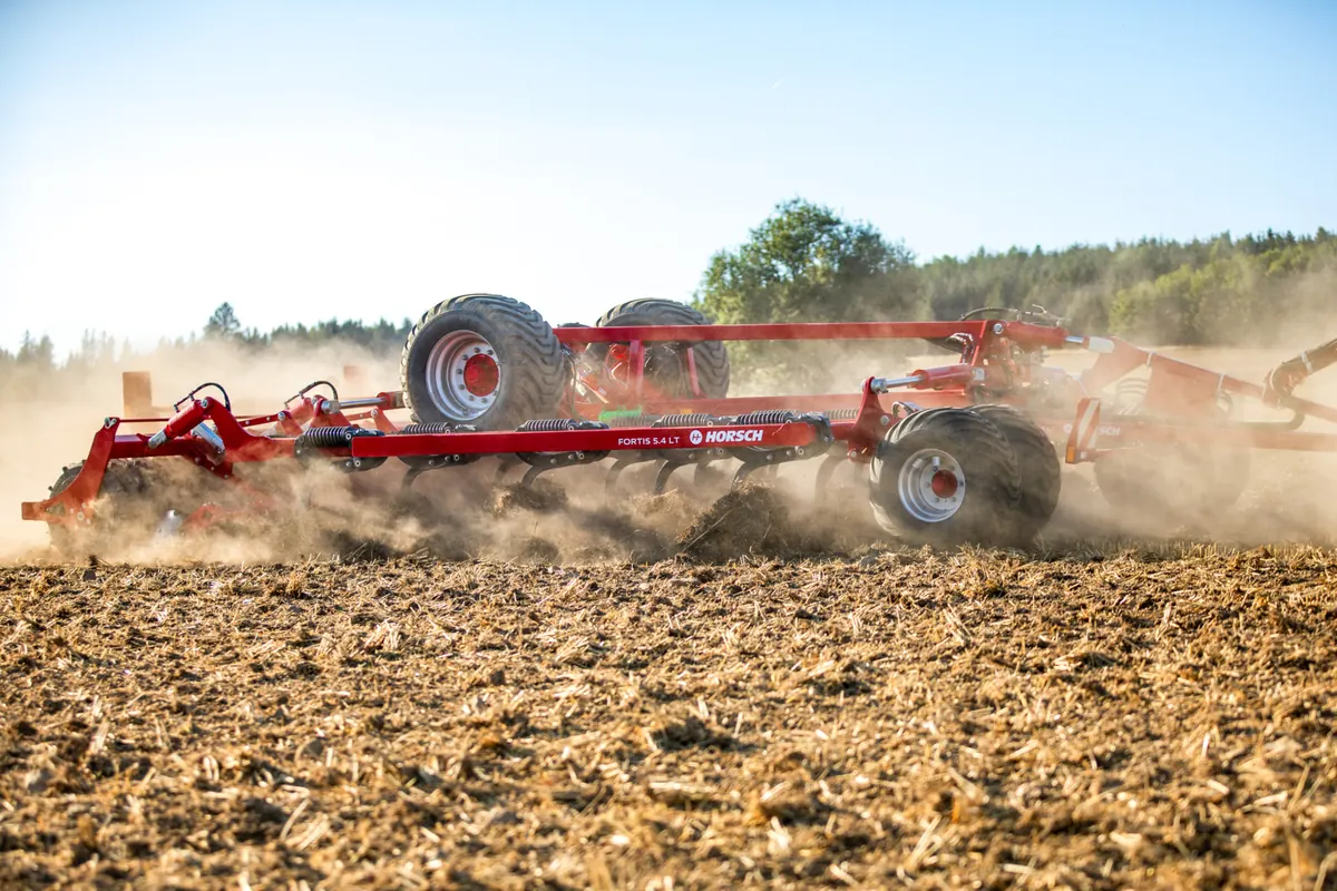 Cultivador Horsch Fortis LT treballant entre un núvol de pols, amb la terra oberta en primer terme