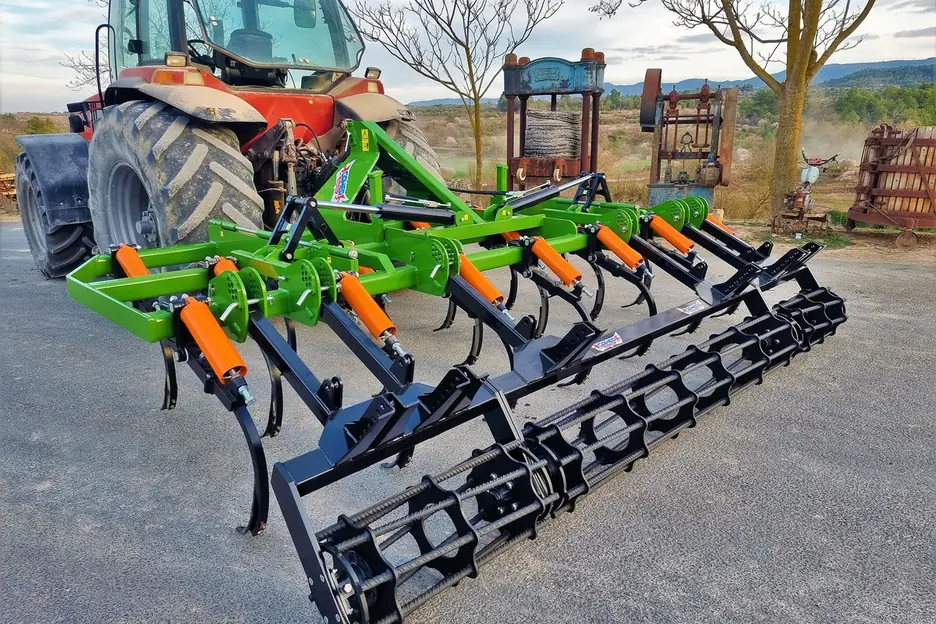 Semixissel plegable Gaher desplegat darrere d'un tractor vermell, sobre asfalt, amb el corró de barres al darrere