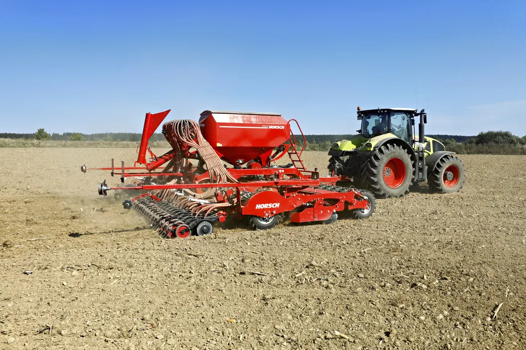 Sembradora Horsch Pronto DC Classic desplegada darrere d'un tractor, en un camp sec