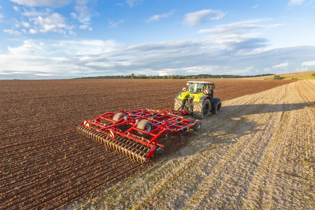 Vista aèria d'un cultivador Horsch Terrano GX arrossegat, amb el corró al darrere, obrint la meitat d'un camp de rostoll